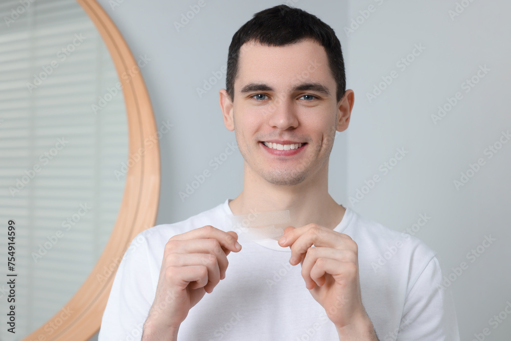 Young smiling man with whitening strips indoors Young smiling man with whitening strips indoors