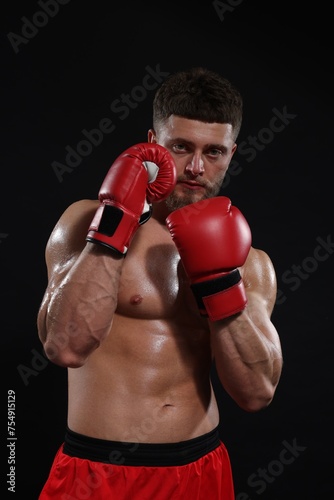 Man in boxing gloves on black background © New Africa