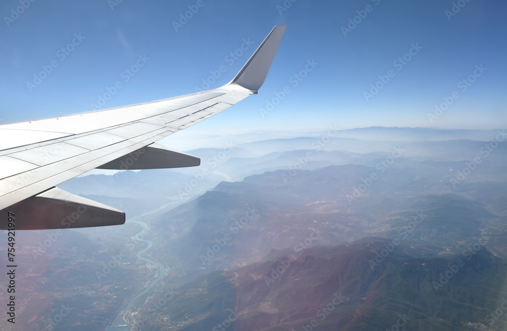 plane wing and mountain of China on sky through window frame plane wing and mountain of China on sky through window frame