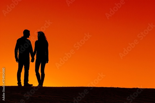 Couples shadows merging at sunset on a vivid orange background in a dramatic silhouette art style with copyspace
