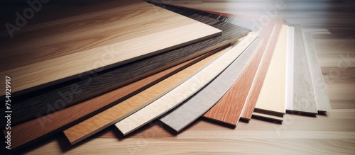 A pile of hardwood boards is stacked on a wooden floor, waiting to be used for building or wood flooring. They may be treated with wood stain or used for laminate flooring