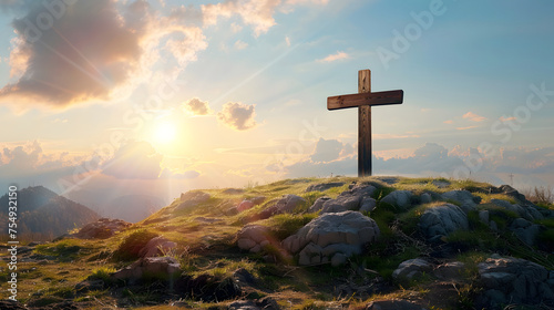 A wooden cross is placed on top of a rocky hill. The sky is blue with white clouds and a bright sun is shining  photo
