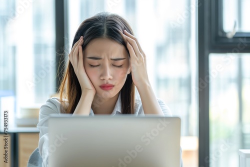 Young beautiful asian womanhad a strong headache. Sitting at a desk with a laptop. Free Download Young beautiful asian womanhad a strong headache. Sitting at a desk with a laptop. - GFXLoad