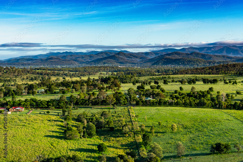 Vue aérienne d'un paysage de la campagne située à l'Ouest de la ville d'Ipswich (Queensland, Australie). En arrière plan une chaine de montagnes coiffée de quelques nuages.