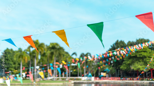 Summer fair flag bunting colorful background hanging on blue sky for fun fiesta party event, summer holiday farm feast celebration, carnival festival event, park or street festa design decoration