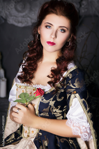 Canvas Print Beautiful woman in an old dress with a train and a rose in his hand