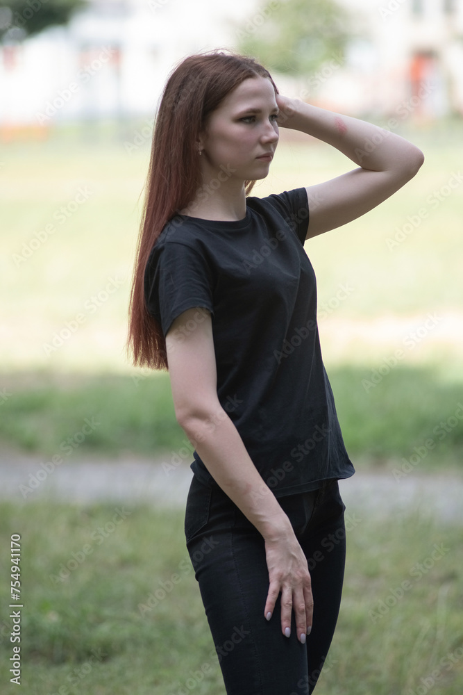 Portrait of a young beautiful red-haired girl in an urban environment. Portrait of a young beautiful red-haired girl in an urban environment.