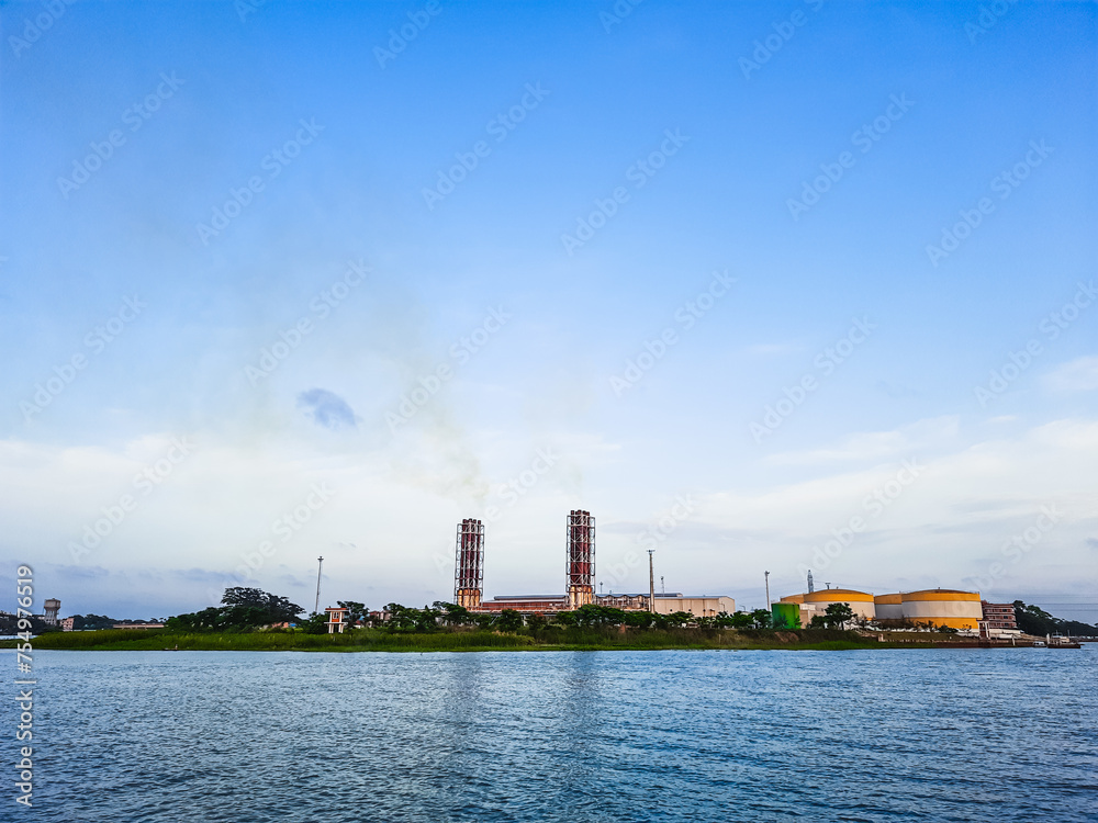 High pollution from power plant. Power plant on the coast. Ecology disaster concept. Power plant high pipes with black smoke moving up polluting atmosphere. High pollution from power plant. Power plant on the coast. Ecology disaster concept. Power plant high pipes with black smoke moving up polluting atmosphere.