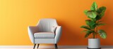 A cozy armchair and a small table with a potted plant are placed in front of an orange wall. The setting exudes warmth and simplicity, creating a sense of coziness in the room.