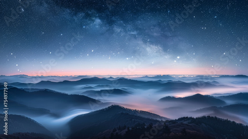 The sky is filled with stars and the mountains are covered in fog. The scene is serene and peaceful, with the fog adding a sense of mystery and calmness to the landscape