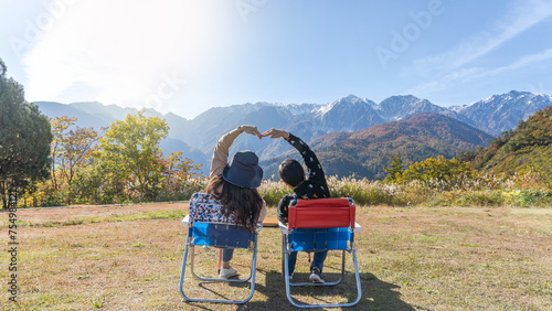 Mountain traveler couple relaxing, take it easy enjoying tourist adventure mountaintop travel freedom, mountaineering height of outdoor hill top trip with panoramic view of nature peak and sky horizon