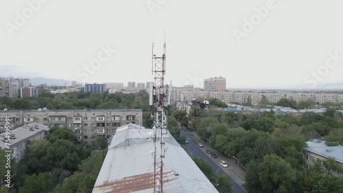 Aerial footage around a telecommunications tower with sector antennas of a mobile operator and radio relay equipment in the city. Telecommunication equipment in Kazakhstan. 5G technology. Telecomphone photo