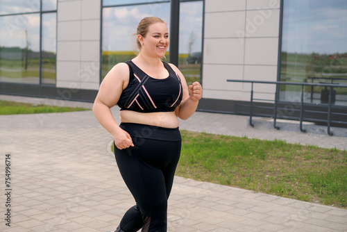 Fotografía A fat, obese, happy, smiling woman in sports clothes on a jog