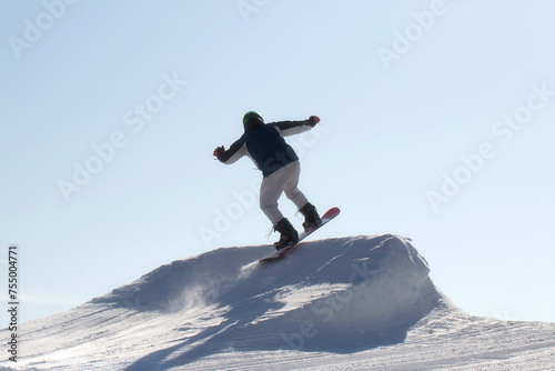 A snowboarder rides a snowboard. Winter recreation.Snowboarding on the mountain.