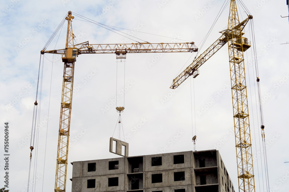 Construction of residential buildings. High tower crane at a construction site