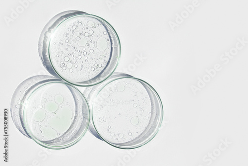 Petri dish. Petri cups with liquid. Kit. Chemical elements  oil  cosmetics. Gel  water  molecules  viruses. Close-up. On a white background.