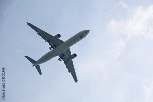 Airplane flying in sky with white clouds. Passenger plane at flight