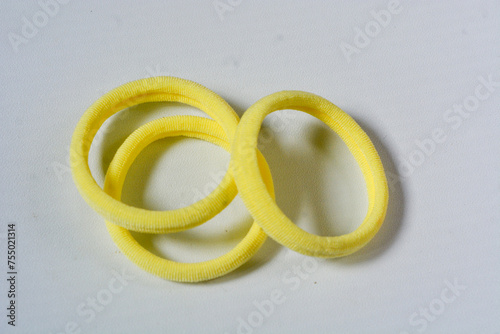A hair scrunchie as a hair tie in a beautiful pastel yellow color made from satin fabric with a white background, so elegant and fashionable. Great hair tie accessory for girls and women.