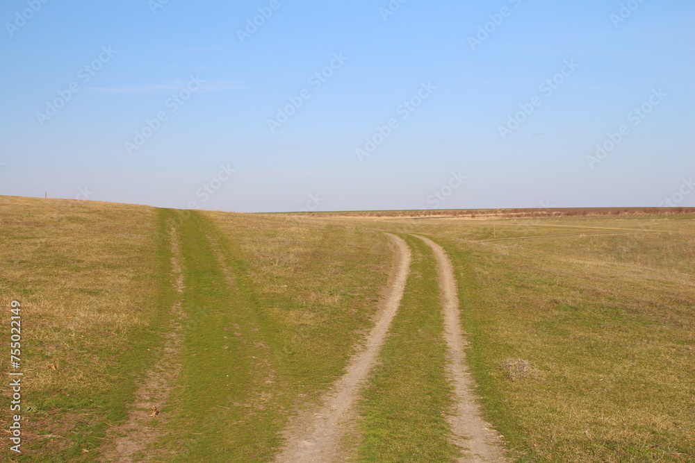 A long straight road through a field