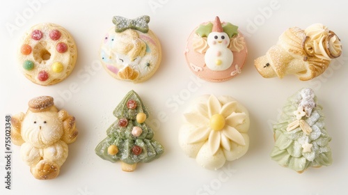 a group of small decorated cookies sitting on top of a white table next to a cupcake on top of a plate.