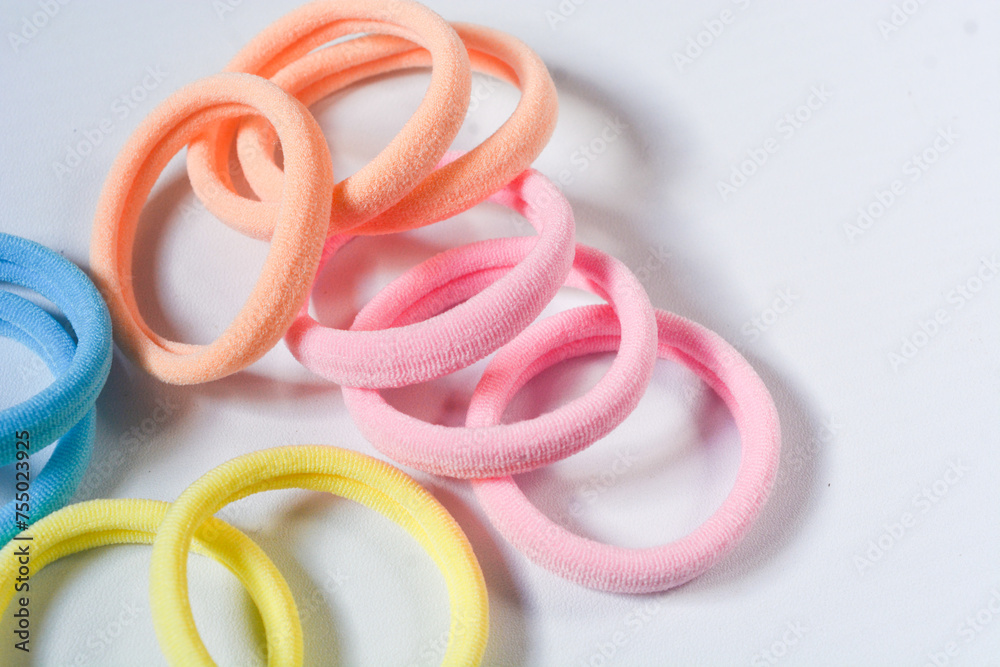 Fototapeta premium Heap of various hair ties. Multicolored elastics isolated on white background