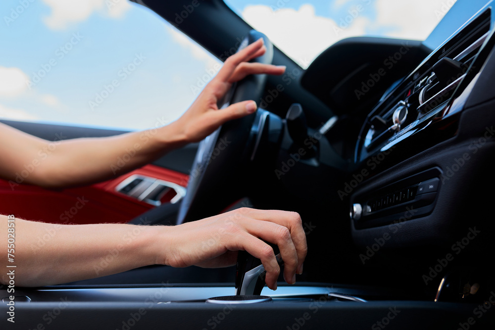 A modern car driven by an unrecognisable woman. The concept of traveling by car A modern car driven by an unrecognisable woman. The concept of traveling by car