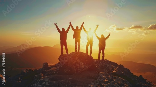 Image of 5 young men standing with their arms raised. Looking ahead on a high mountain The concept of conquering high mountain peaks that are inaccessible to most people. sunset light