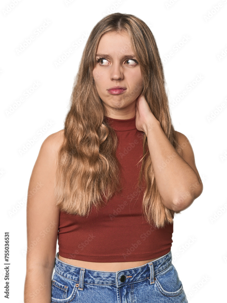Studio portrait of a blonde Caucasian woman touching back of head, thinking and making a choice.