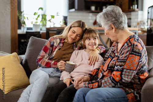 Generational bonding, grandmother, daughter, and grandchild sharing stories on a cozy afternoon © BGStock72