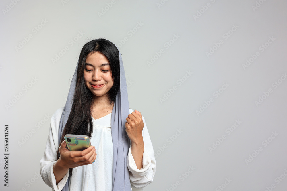 Indonesian Female with Veil Happy Using Mobile Phone, Excited Smile. Indonesian Female with Veil Happy Using Mobile Phone, Excited Smile.