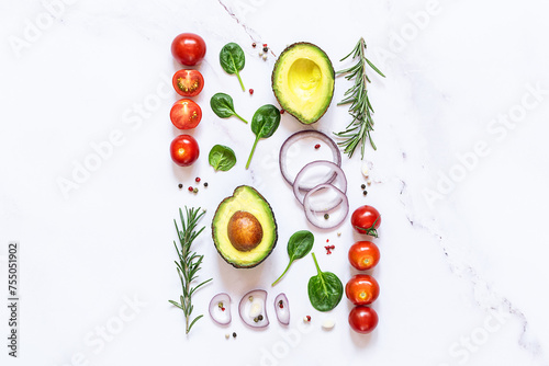 Bright composition with white picture frame with assortment of salad ingredients on white marble table top view, healthy tasty food concept. 