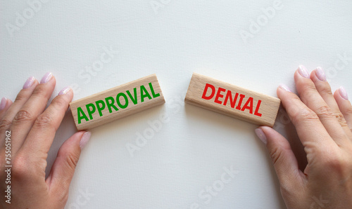 Approval or Denial symbol. Concept word Approval or Denial on wooden blocks. Businessman hand. Beautiful white background. Business and Approval or Denial concept. Copy space