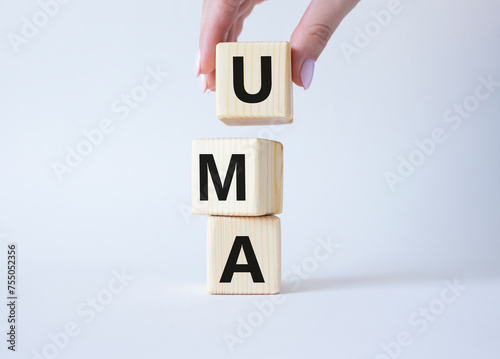 Wallpaper Mural UMA - Unified Managed Account. Wooden cubes with word UMA. Businessman hand. Beautiful white background. Business and Unified Managed Account concept. Copy space. Torontodigital.ca