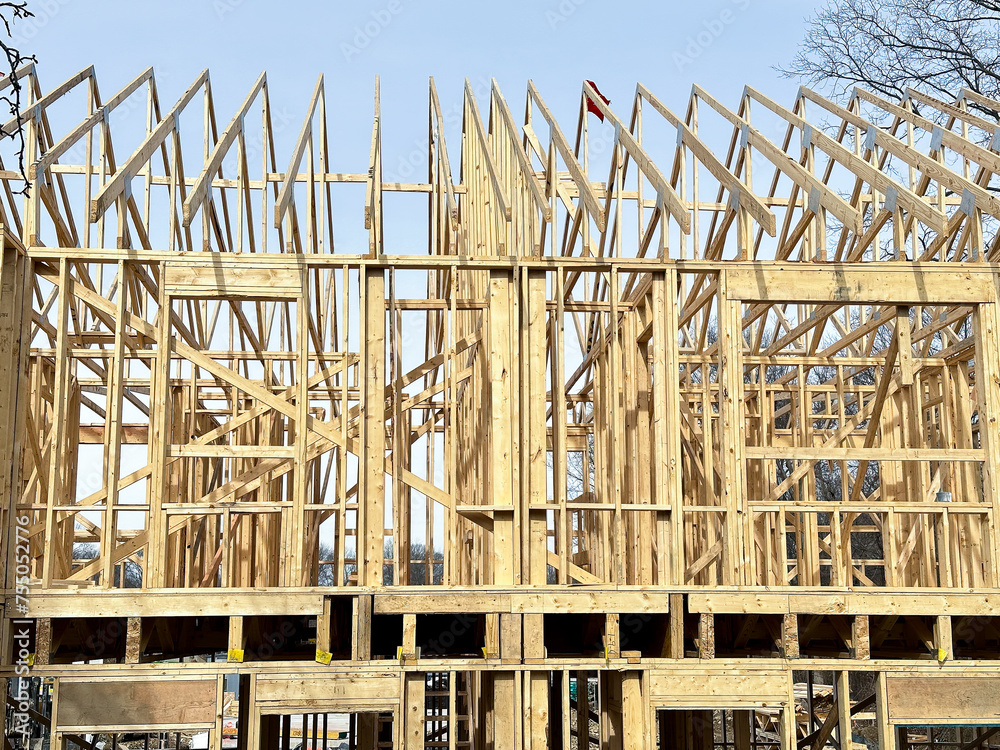 Construction of a new wooden residential building framework during daytime Construction of a new wooden residential building framework during daytime