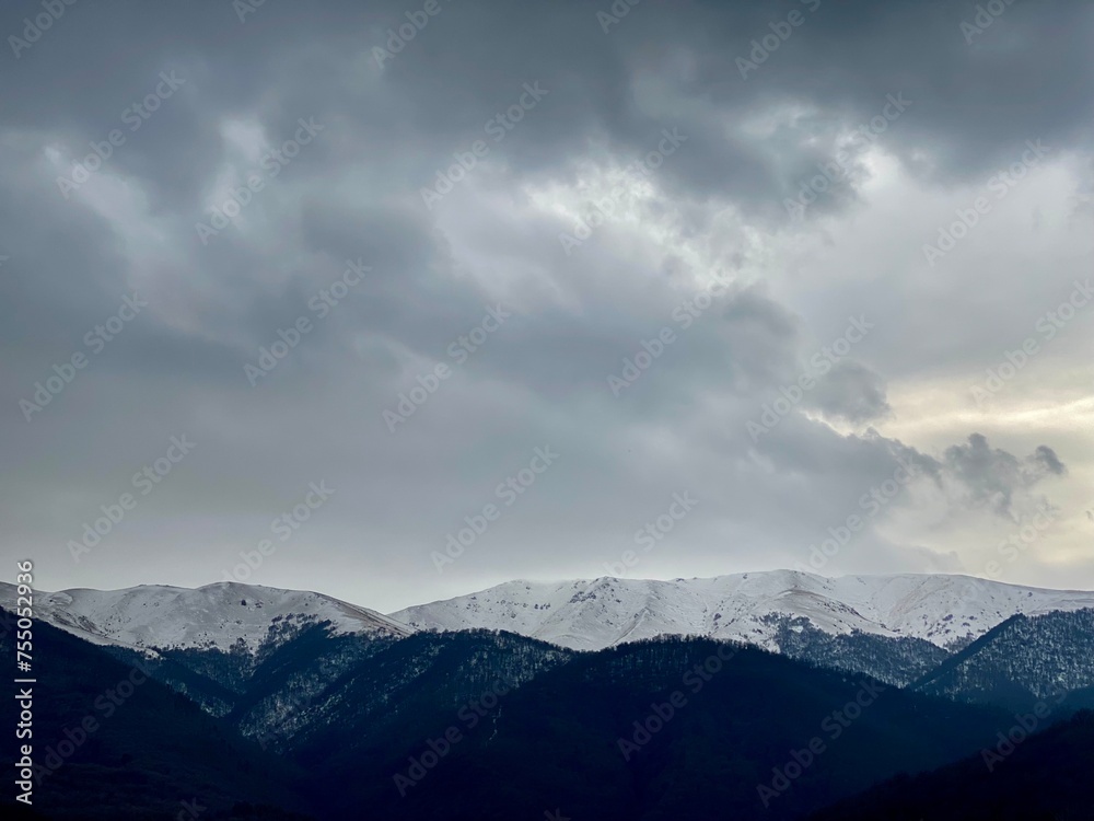 Snow-covered mountains under a cloudy sky