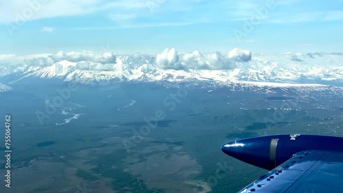 Beechcraft Bonanza airplane wingtip flies over Lake Clark Pass in Alaska. Mount Redoubt in the background. Small aircraft are only way to see many areas of Alaska.