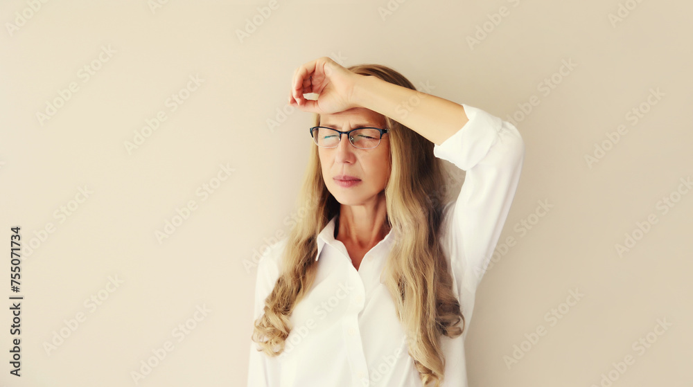 Exhausted tired mature woman employee with headache, suffering from migraine
