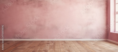 This image showcases an empty room with a soft pink concrete wall and a large window. The room appears spacious with a wooden floor, giving it a warm and inviting feel.