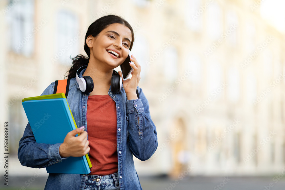 Cheerful young indian woman student have phone conversation outdoors Cheerful young indian woman student have phone conversation outdoors