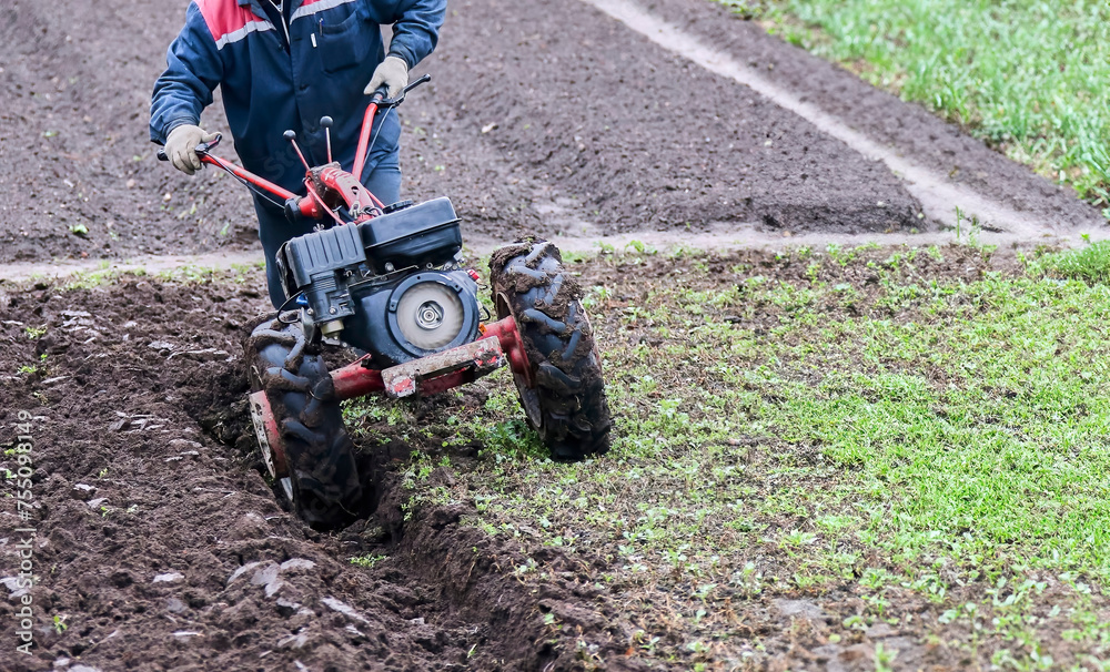 Tractor plowing field in rural area, preparing soil for planting season Tractor plowing field in rural area, preparing soil for planting season