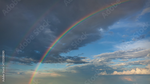 Rainbow after storm with clouds at beautiful sunset as natural background