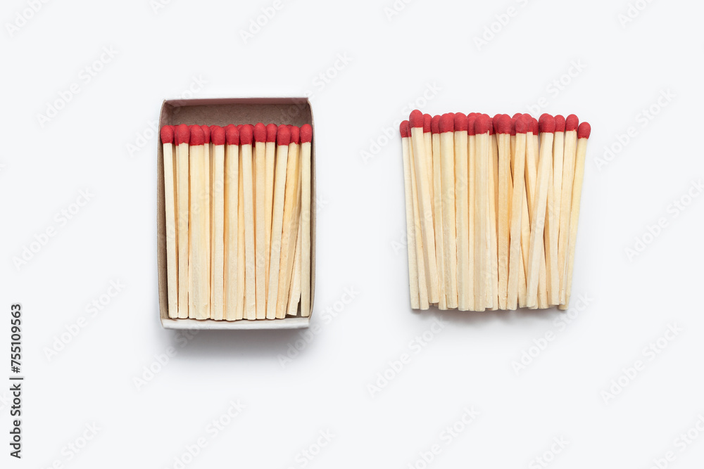 Matches in an open matchbox and many matches near the matchbox isolated on white background. Red matches on a white background are vertically arranged. Top view of matches close-up with space for text Matches in an open matchbox and many matches near the matchbox isolated on white background. Red matches on a white background are vertically arranged. Top view of matches close-up with space for text