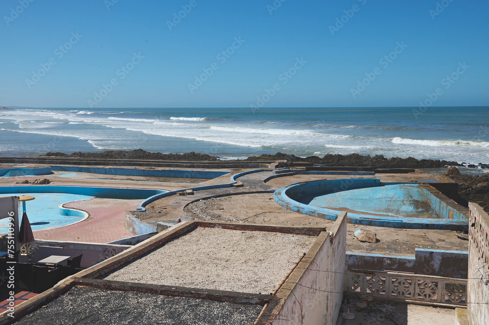 Abandoned swimming pool on the rooftop in Casablanca city, Atlantic beach on the background