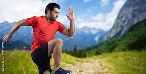 Athletic and sporty man running posture at outdoor mountain exercise session for fit physique and healthy outdoor sport lifestyle. Gaiety green natural exercise workout training.