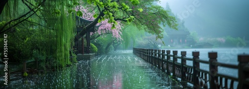 Amidst the serene beauty of a Japanese arboretum, a rain-soaked wooden bridge crosses over a lake, surrounded by cherry and willow trees.