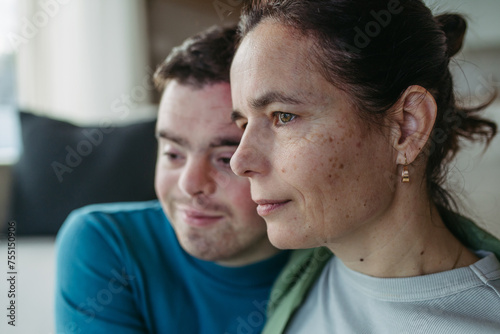 Portrait of young man with Down syndrome with mother at home, holding, touching with foreheads. Concept of love and parenting disabled child. © Halfpoint
