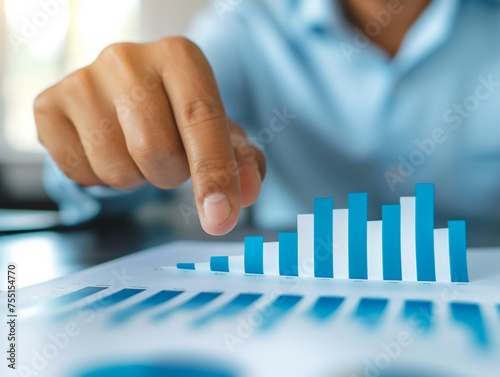 A business professional analyzes statistical growth using bar graph charts, indicative of financial analysis and corporate strategy