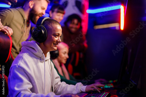 Bald woman gamer playing PC video game on a cybersport tournament