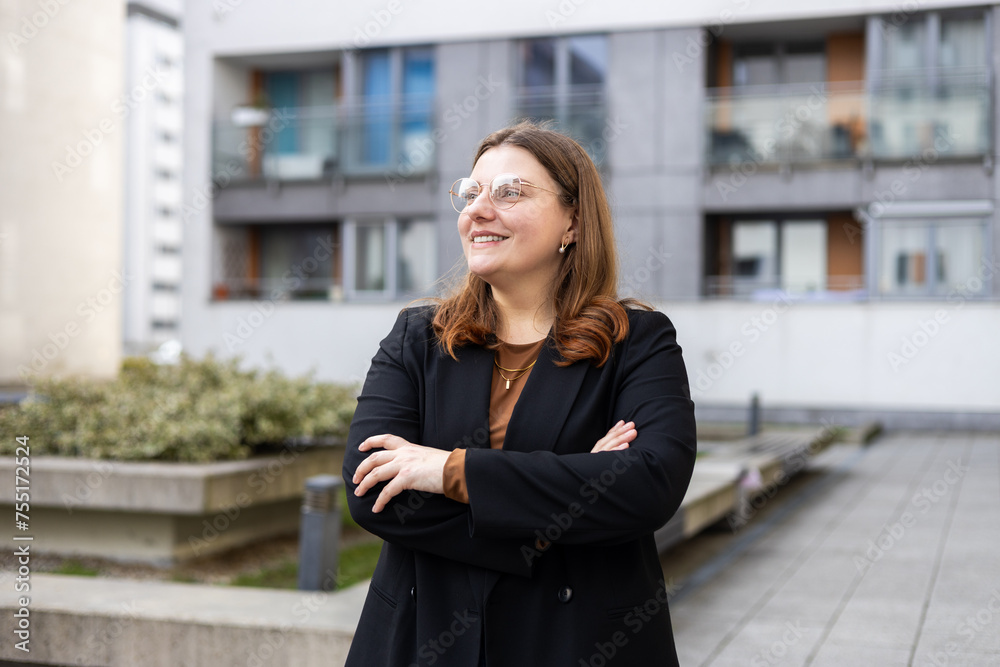Caucasian 30s businesswoman standing in front of a building. Successful confident professional manager leader entrepreneur corporate employee posing with arms crossed on street Caucasian 30s businesswoman standing in front of a building. Successful confident professional manager leader entrepreneur corporate employee posing with arms crossed on street