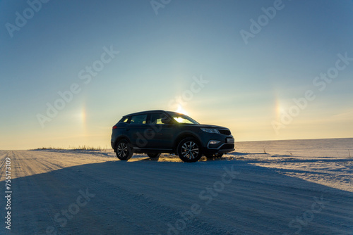 Winter landscape with car and circular halo phenomena around the sun © BY-_-BY